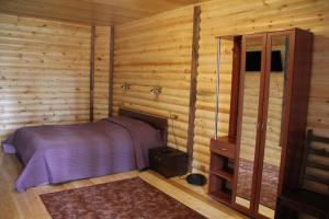 1 dormitorio con 1 cama en una cabaña de madera en Park Hotel Manzherok, en Manzherok