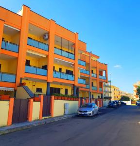 ein orangenes Gebäude mit einem davor geparkt in der Unterkunft Case Vacanza IonianTravel Gallipoli in Gallipoli