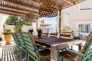 een eetkamer in de openlucht met een houten tafel en stoelen bij Casa Verde Guesthouse in Muchamiel