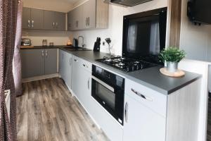 a kitchen with a black and white stove top oven at Black Bull Retreat, Barmston with Private Hot Tubs in Great Driffield