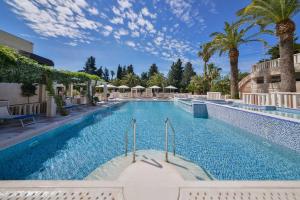 una piscina en un hotel con palmeras en Mediteran Hotel & Resort, en Budva