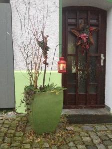 a green planter with a light in front of a door at Ferienwohnungen Riedel in Pegnitz