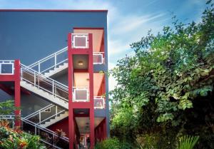 a red building with a staircase next to some trees at Seaview Gardens Hotel in Kololi