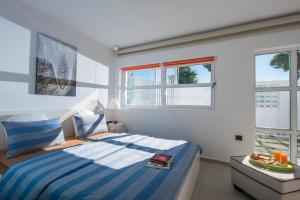 um quarto com uma cama e duas janelas em White Luxury Villa em Hersonissos