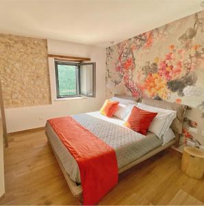 una camera da letto con un letto con cuscini rossi e bianchi di Arenarius Home Resort & SPA a Torricella in Sabina