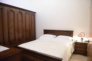 カロヴィーニョにあるAppartamento nuovo indipendente situato a 100 m dal centro storicoのベッドルーム1室(木製ヘッドボード付きのベッド1台付)