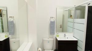 een badkamer met een toilet, een wastafel en een spiegel bij Rooftop by Check-in Portugal in Albufeira