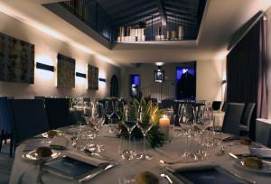 Podere Castel Merlo Resort في Villongo SantʼAlessandro: غرفة طعام مع طاولة مع كؤوس للنبيذ