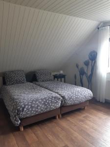 a bed in a room with a white ceiling at B&B De Kandelaar in Biddinghuizen