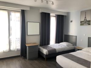 a hotel room with two beds and the eiffel tower at Hôtel Clauzel Paris in Paris