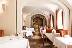 a restaurant with white tables and chairs and a corridor at Schlossgut Gross Schwansee in Groß Schwansee