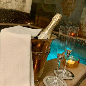 una bottiglia di champagne seduta su un tavolo con due bicchieri di Arenarius Home Resort & SPA a Torricella in Sabina