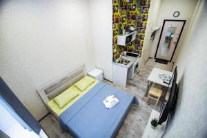 バルナウルにあるСтудия ЦЕНТР города, Красноармейский 96аの青いベッドとテーブルが備わる小さな客室です。