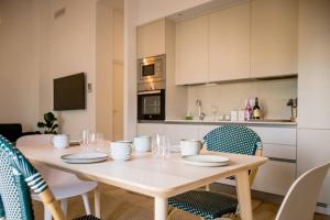 uma mesa de jantar com cadeiras e uma cozinha em Fantastico apartamento recien renovado con piscina en la azotea, dos dormitorios y aparcamiento gratuito en la calle. em Sevilha