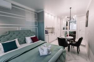 een slaapkamer met een bed en een tafel en een keuken bij Royal Tower VIP Smart Apartments 1 in Kiev