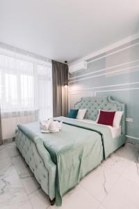 een slaapkamer met een groot groen bed met rode kussens bij Royal Tower VIP Smart Apartments 1 in Kiev