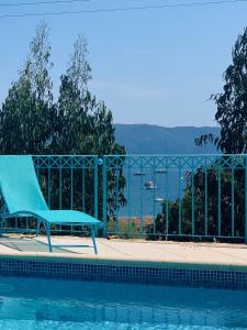 una sedia blu seduta accanto alla piscina di Villa Turquoise Sagone a Sagone