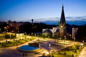 un grande edificio con torre dell'orologio e chiesa di Pálma Apartmanok Szálláshely Százhalombatta 5a a Százhalombatta