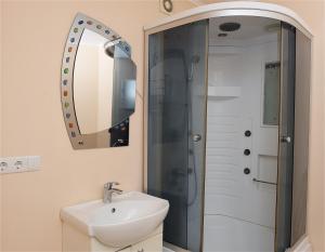 a bathroom with a sink and a shower with a mirror at Двухкомнатная квартира с видом на Днепр в новом жилом комплексе! in Cherkasy