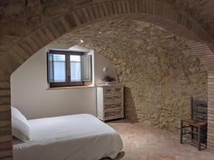 a bedroom with a bed in a stone wall at Can Puig CAVE in La Pera