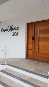 una puerta delantera de un edificio con un cartel en Apartamento super confortável, Torres RS, en Torres