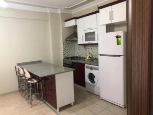a kitchen with a white refrigerator and a dishwasher at Almasa Suite Aparts in Termal
