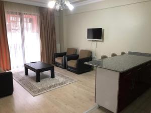 un salon avec une cuisine et un salon avec des chaises dans l'établissement Almasa Suite Aparts, à Termal