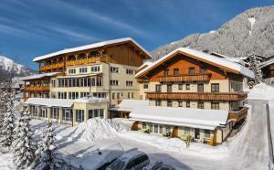 um grupo de edifícios na neve em Hotel-Gasthof Andreas em Obertilliach