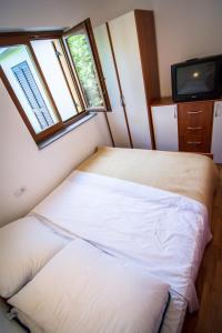 two beds in a small room with a tv at Holiday Home Dubi in Kornić