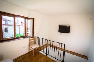 a room with a chair and a television on a wall at Holiday Home Dubi in Kornić