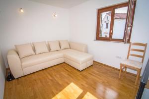a living room with a couch and a chair at Holiday Home Dubi in Kornić