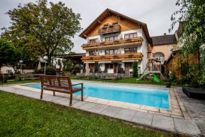 ein Haus mit einem Pool vor einem Haus in der Unterkunft Landgasthof Moser & Restaurant Bootshaus in Windorf