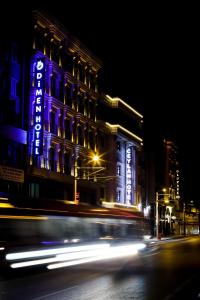 un edificio con una señal azul en él por la noche en Dimen Hotel en Bursa