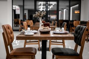 ein Holztisch mit einer Schale mit Essen und Blumen darauf in der Unterkunft Dimen Hotel in Bursa