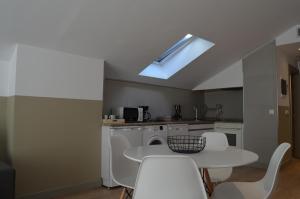 a kitchen with a white table and white chairs at Hotel Airiños 3* in Cangas de Morrazo