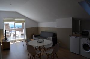 a living room with a table and a couch at Hotel Airiños 3* in Cangas de Morrazo
