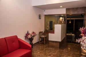 a living room with a red couch and a table at Stone shelter in Mahabaleshwar