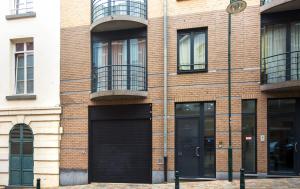a brick building with black garage doors and windows at Center Design Residence in Brussels
