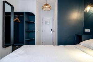 1 dormitorio con 1 cama blanca y paredes azules en Beverly Hills Hotel en Bruselas