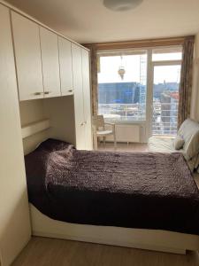 ein Schlafzimmer mit einem Bett und einem großen Fenster in der Unterkunft "Hasselt" - Amazing Seaview apartment in Ostende