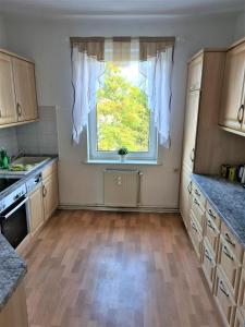 una cucina con una grande finestra e un pavimento in legno di Ferienwohnung mit Seeblick a Brandenburg an der Havel