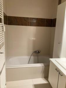 eine weiße Badewanne im Bad mit Waschbecken in der Unterkunft "Hasselt" - Amazing Seaview apartment in Ostende