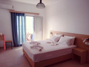 a bedroom with a bed with white sheets and a window at Calypso in Agia Roumeli