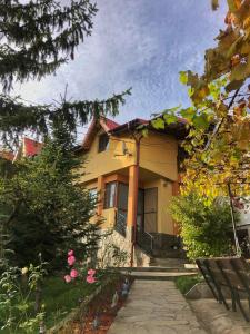 una casa gialla con un sentiero di fronte di Pensiunea PORTAS RESORT a Slănic