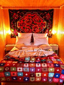 1 dormitorio con 1 cama con colcha colorida en Pensiunea PORTAS RESORT, en Slănic