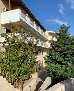 an apartment building with two trees in front of it at Parnis Palace in Athens