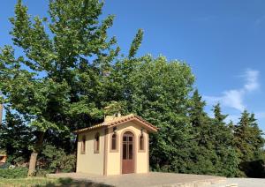 une petite chapelle dans une cour avec des arbres en arrière-plan dans l'établissement Parnis Palace, à Athènes
