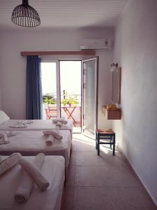 a hotel room with two beds and a balcony at Calypso in Agia Roumeli