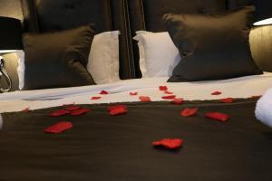 a bed with red rose petals on it at The Bold Hotel; BW Signature Collection in Southport