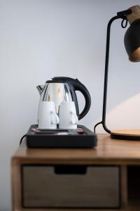 une bouilloire assise sur une table à côté d'une lampe dans l'établissement Beverly Hills Hotel, à Bruxelles